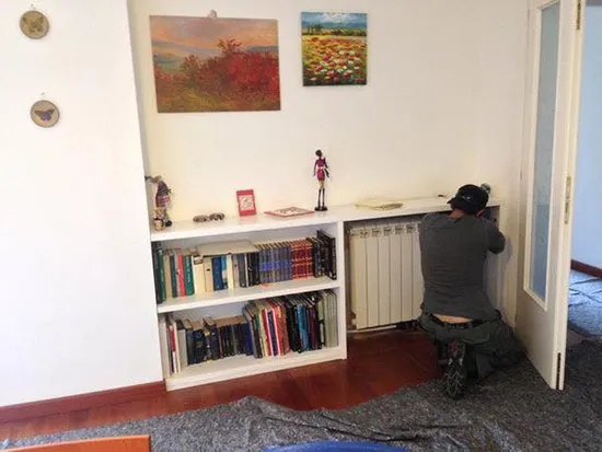 un operaio mentre ripara un termosifone